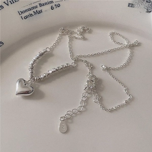 Elegant 925 sterling silver heart pendant necklace displayed on a white ceramic plate