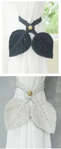 Detail of handmade macramé leaf curtain tiebacks in dark grey and off-white cotton rope