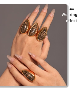 Model wearing vintage 18K gold teardrop wood grain stone rings in a stacked style