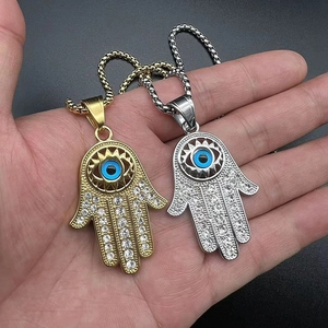 Gros plan de pendentifs Main de Fatma avec œil bleu maléfique et strass scintillants