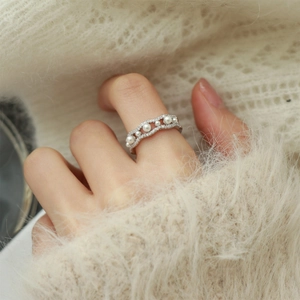 Detailed view of silver wave ring with faux pearls and sparkling pavé crystals