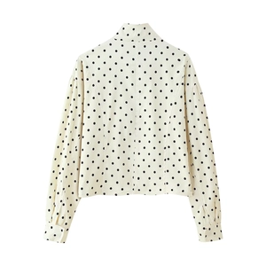 Detailed back view of white long sleeve jacket with black polka dots and stand collar