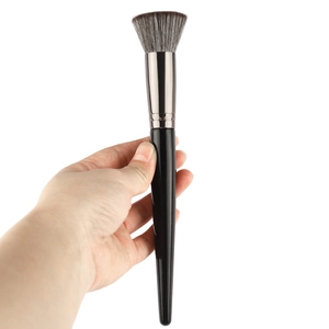 Contour makeup brush with soft dual-tone bristles and black handle shown in hand