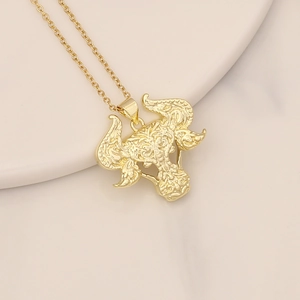 Detailed view of a gold-plated elephant head pendant with intricate patterns on a chain