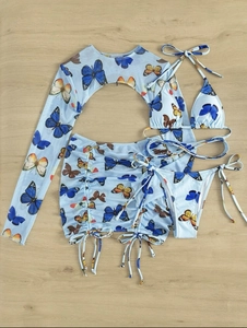 Detail of butterfly print four-piece bikini set with sheer mesh cover-up on wood background