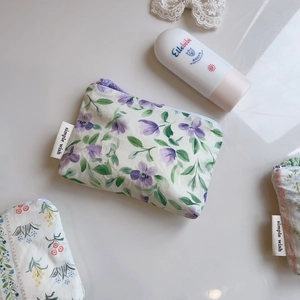Close-up of floral cotton pouches with simple wish label and secure zipper closure