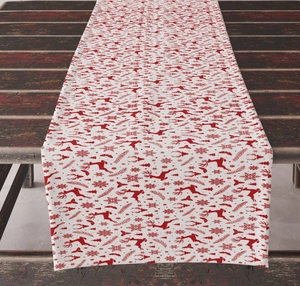 Detail of Christmas table runner with red reindeer and snowflake pattern on dark wood