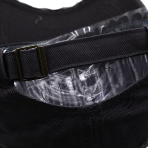 Detail of adjustable bronze metal buckle on a black distressed cotton baseball cap
