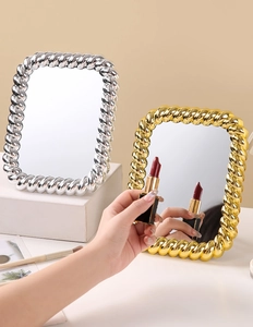 Close-up of European vintage makeup mirrors in gold and silver with twisted rope frame