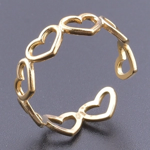 Detail of golden adjustable open ring featuring hollow heart pattern on textured surface