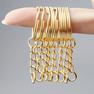 Macro detail of polished gold metal chains and lobster clasps for DIY jewelry making