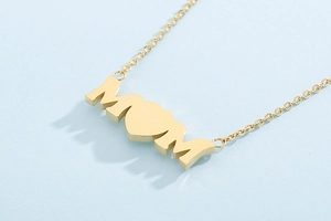 Macro shot of gold MOM pendant with heart opal detail on a delicate steel chain