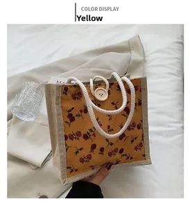 Detail of yellow floral handbag with vintage red roses and rustic cotton rope handles