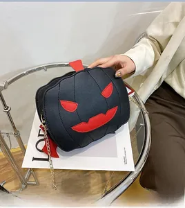 Close-up of Halloween pumpkin crossbody bag with black faux leather and gold chain