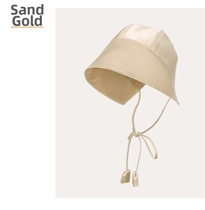 Detail view of the silk sun hat in Quicksand Gold with elegant satin texture and tie straps