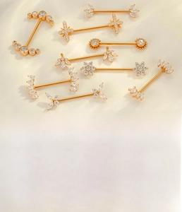 Detailed close-up of gold titanium alloy nipple rings set with sparkling zircon inlays