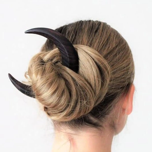 Dark wood crescent moon hair fork shown in a classic hairstyle on a model's hair