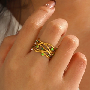 Anello in acciaio al titanio placcato oro 18K con punti smaltati verdi sulla mano