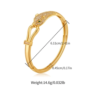 Detail view of gold-plated leopard head bangle with green eyes and product dimensions