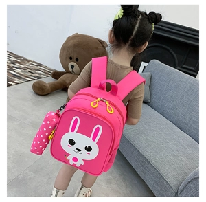 Pink kids backpack with cute white rabbit print and matching pencil case on young girl