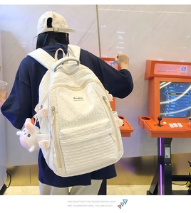 Détail du sac à dos blanc à texture bulles avec porte-clés cochon et grands compartiments
