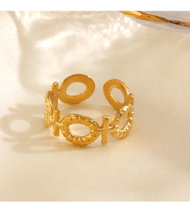 Makro-Detail eines verstellbaren Goldrings mit XO-Muster auf Seidenstoff liegend