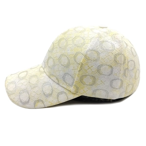 Dettaglio cappellino da baseball in pizzo con motivo geometrico floreale su sfondo bianco