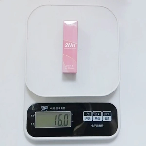 Twee-in-één roze matte lippenstift en lipgloss gewogen op een weegschaal van 16 gram
