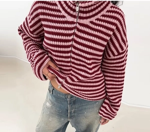 Dettaglio del cardigan a righe rosa e bordeaux con chiusura lampo in metallo argento