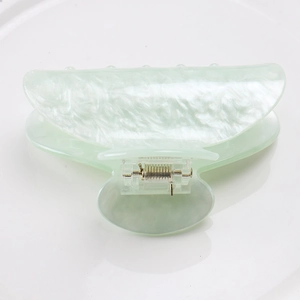 Détail d'une grande pince à cheveux en acrylique vert pâle nacré avec ressort en métal