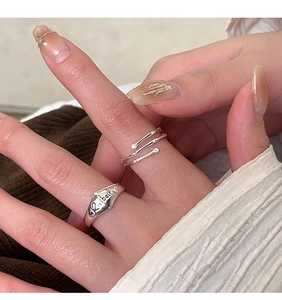 Detailed close-up of S925 silver layered wrap ring and vintage engraved stamp ring on hand