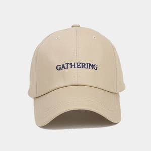 Détail d'une casquette beige avec broderie bleue gathering et texture en sergé de coton