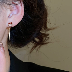 Detail of red enamel butterfly earring with sparkling cubic zirconia and long gold tassels