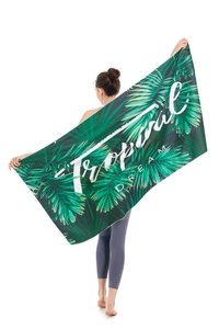 Detail view of tropical palm leaves microfiber beach towel featuring Tropical DREAM text