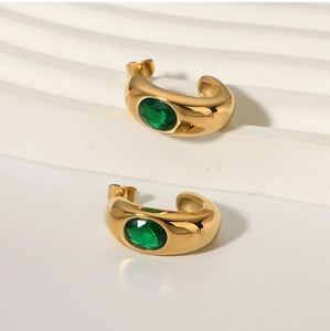 Detail of 18K gold plated C-shaped earrings with oval green zircon stones
