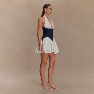 Détail d'une robe dos nu avec tissu blanc et patchwork en denim foncé à la taille haute