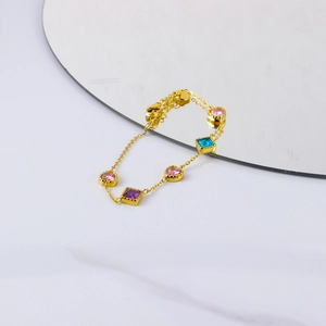 Close-up of 18K gold-plated bracelet featuring pink heart and colorful square zircons