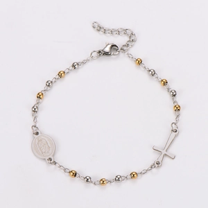 Detail of silver and gold beaded bracelet with cross and Virgin Mary medal charms