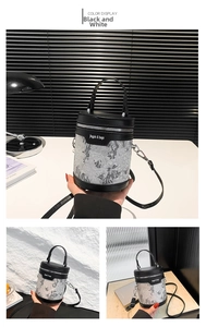 Detail of black and white bucket bag with lace embroidery and leather top handle