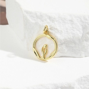 Macro shot of gold tulip relief on a round white shell pendant over white stone