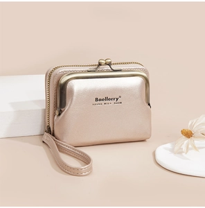 Detail of champagne gold leather wallet with vintage kiss lock and brand logo engraving