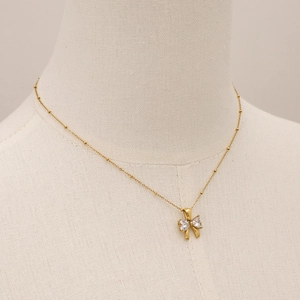 Collier nœud en acier inoxydable doré avec zircons brillants sur un mannequin de mode