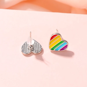 Detailed view of rainbow heart stud earrings with silver metal back and silicone plugs