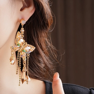 Détails des boucles d'oreilles papillon en cristal avec pompons dorés et strass verts