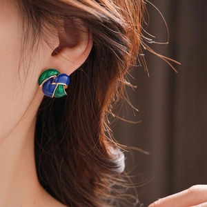 Vintage French style blue and green enamel earrings with gold trim on model ear