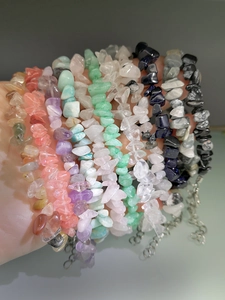 Close-up of hand holding colorful natural irregular crystal stone bracelets with lobster clasp