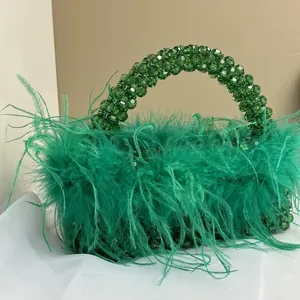 Detailed view of handmade emerald green ostrich feather evening bag with clear beaded handle
