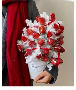 Close-up of a creative strawberry bouquet with faux white branches and red ribbon packaging
