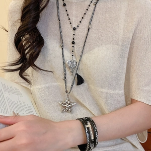 Détail d'un ensemble de colliers bohèmes en corde tressée avec breloques étoile et coeur