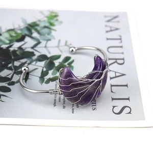 Macro detail of silver wire-wrapped crescent amethyst on tree of life bangle
